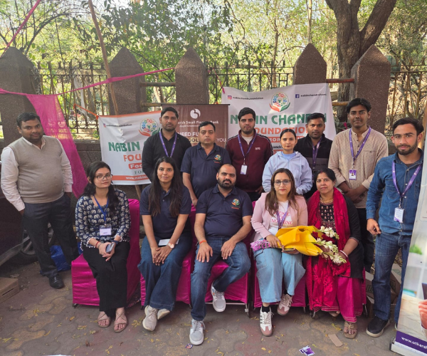Group of volunteers and organizers in front of the NGO banner