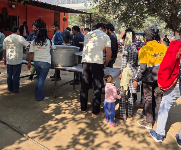 Volunteers distributing meals, including to a delivery rider