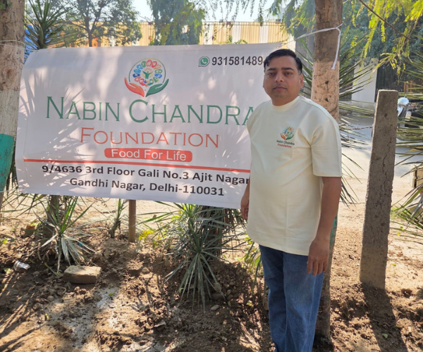 Man in NGO shirt in front of the foundation banner outdoors