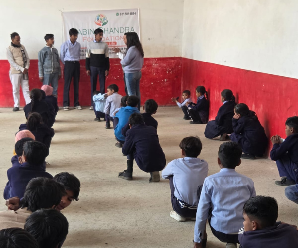 Woman interacting with school children sitting on the floor
